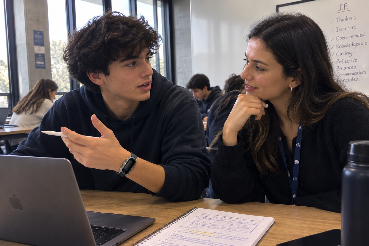 Student discussing work with a teacher, wearing Trace